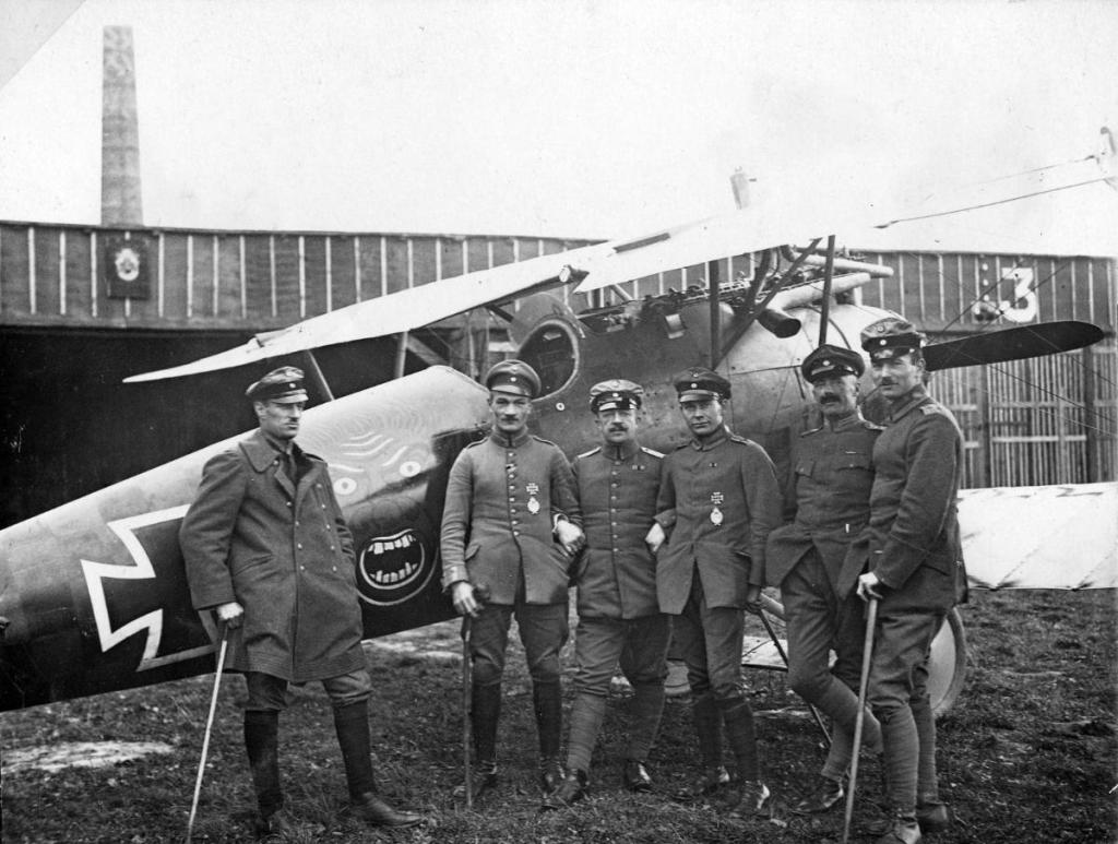 Fritz Rumey (2nd from left) in front of his snarling head (African savage) marked Albatros DVa of Jasta 5.jpg